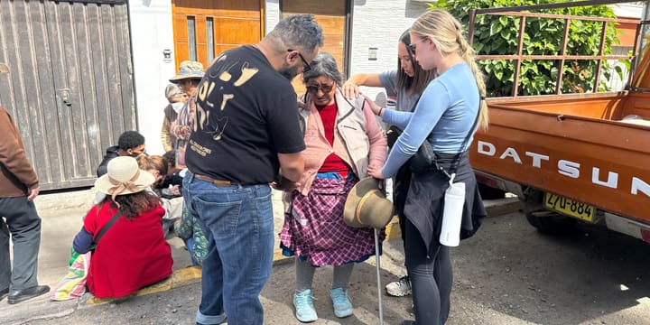 Chaplain Kris praying with an elderly woman on a street in Peru